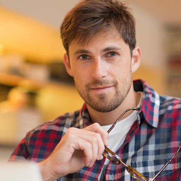 Portrait confident man working at laptop in cafe